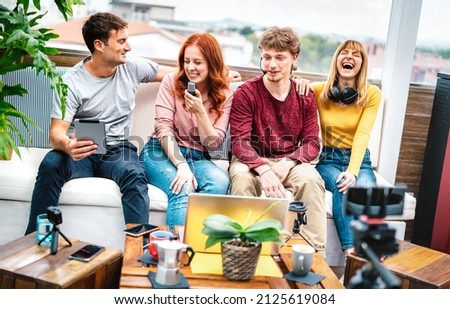 Trendy milenial people having fun on streaming platform with web cam - Content marketing concept with millenial guys and girls sharing live vlog feeds at modern open space office - Bright vivid filter Royalty-Free Stock Photo #2125619084