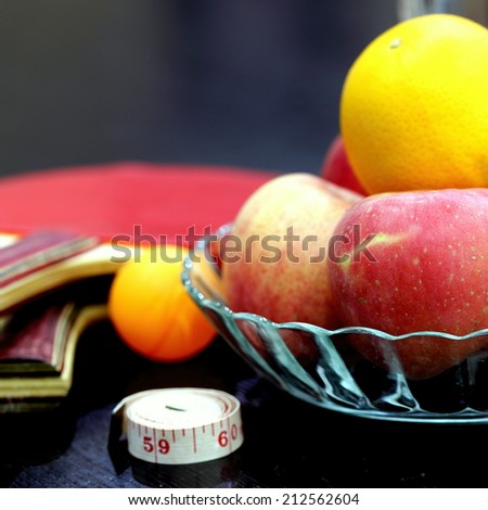 Apples, Oranges, Table Tennis and Soft Ruler Illustrating Concept of Healthy Living  