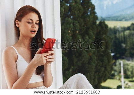 beautiful woman use the phone looks at the screen in a comfortable hotel an open view of the Mountain View