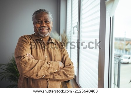 African American Senior Man at home Portrait. Smiling senior man looking at camera. Portrait of black confident man at home. Portrait of a senior man standing against a grey background Royalty-Free Stock Photo #2125640483