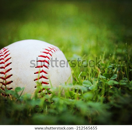  a square photo of a baseball in a grass background toned with a vintage retro instagram filter  effect