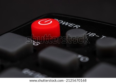 TV power button on the remote control on black background.