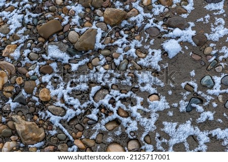 The river bank, sand and rocks.