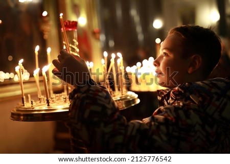 Portrait of kid with candle in russian orthodox church Royalty-Free Stock Photo #2125776542