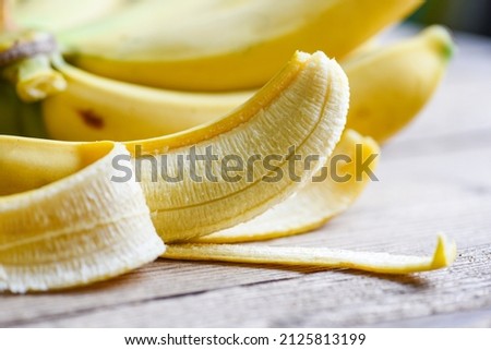 banana peel on wooden background, Close up ripe banana peel on floor Royalty-Free Stock Photo #2125813199