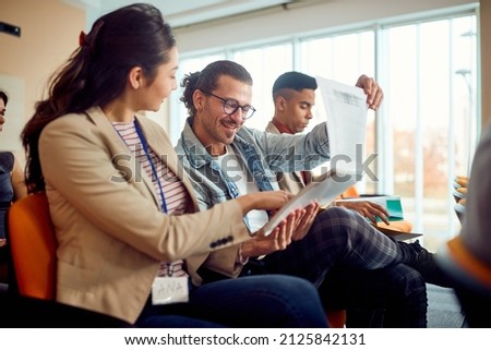 Young participants at a business lecture in a pleasant atmosphere in the conference room are analyzing writings together. Business, people, company Royalty-Free Stock Photo #2125842131