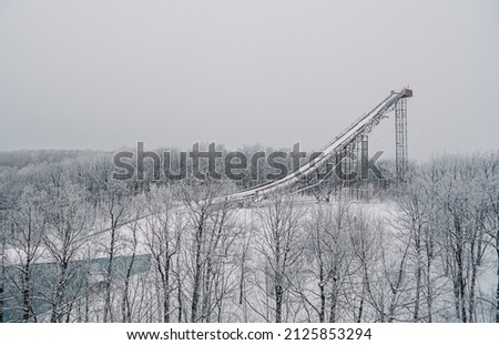 Ski jumping slopes or towers in Tatarstan, Russia. Ramps surrounded by snow-covered trees on a hill . Ski jumping ramp