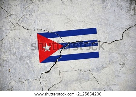 An old image of the flag of Cuba on a wall with a crack. A crisis.