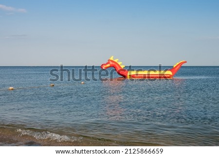Inflatable boat "banana", designed as cartoon dragon. Marine theme	