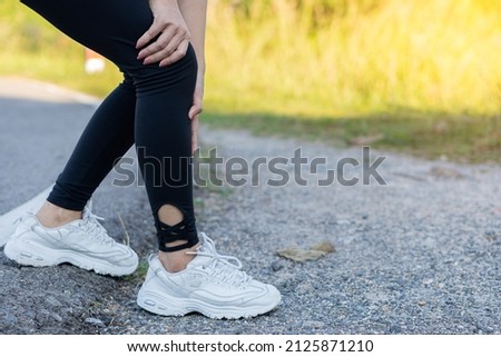 Female runners have leg cramps from accidents, sports injuries, knee pain, and problems after running and exercising outdoors in the summer. Royalty-Free Stock Photo #2125871210