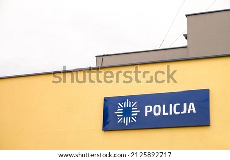 Translation: "Police" sign in Poland Polish saying Police. Police station sign in Poland.