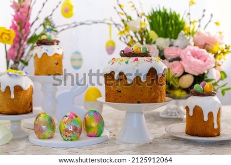 Festive Easter table setting. Easter cake, Easter Eggs, Flower arrangements and home decorations for holiday. Royalty-Free Stock Photo #2125912064