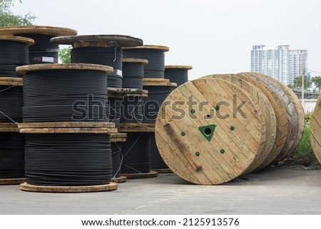 Wooden Coils Of Electric Cable Outdoor. High and low voltage cables in the storage. Royalty-Free Stock Photo #2125913576