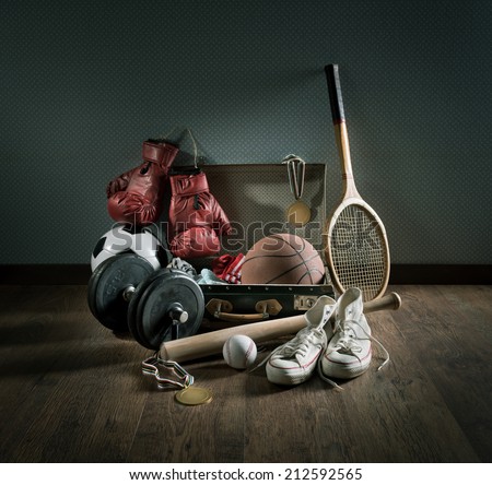 Teenager sport equipment in a vintage suitcase including sports footwear, boxing gloves, weights and baseball bat. Royalty-Free Stock Photo #212592565