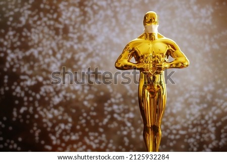Hollywood Golden Oscar Academy award statue in medical mask on fireworks background. Success and victory concept. Oscar ceremony in coronavirus covid-19 time