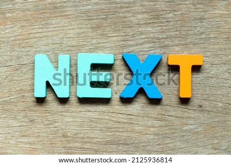 Color alphabet letter in word next on wood background