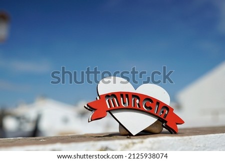 Close up heart in the corner with the word of murcia and the background of sky, blue and clouds. Andalusia, Spain