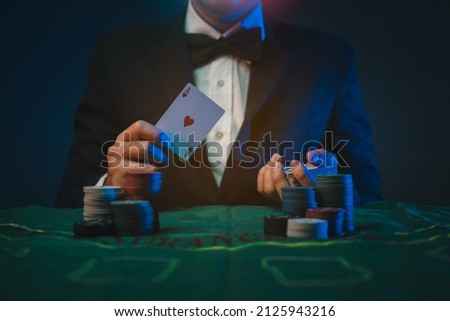 Man dealer or croupier shuffles poker cards in a casino on the background of a table,asain man holding two playing cards. Casino, poker, poker game concept Royalty-Free Stock Photo #2125943216