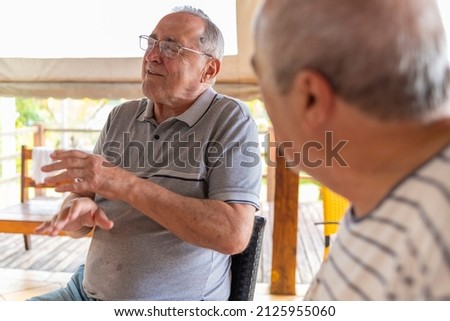 old man emotional while friend watches him, narrow focus