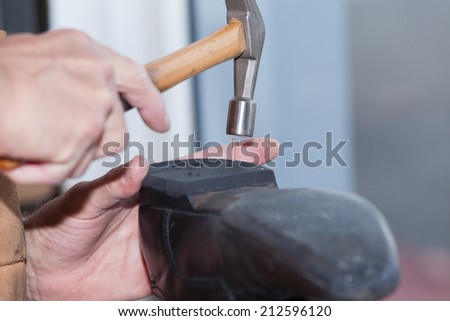 the shoemaker repairs a shoe Royalty-Free Stock Photo #212596120