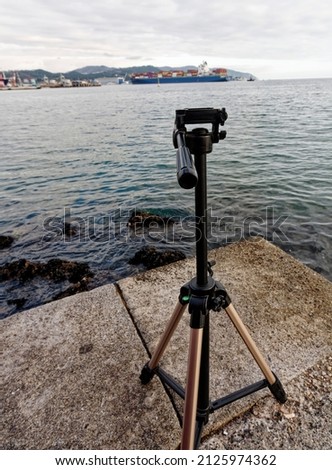 Dslr digital professional camera stand on tripod photographing sea, in la spezia gulf 