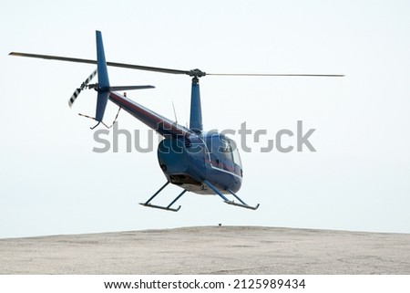 Navy helicopter flying against bright blue sky background, 