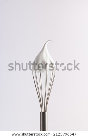 Merengue. Confectionery whipped cream on a whisk Royalty-Free Stock Photo #2125996547