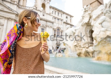 Woman eating ice cream in cone while visiting famous Navona square near fountain in Rome. Concept of happy summer vacations, traveling famous italian landmarks Royalty-Free Stock Photo #2125997726