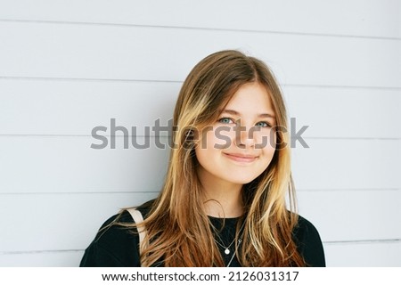 Outdoor close up portrait of pretty young teenage gir with brown hair posing on white background