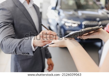 Cropped up photo man customer male client buyer in suit choose auto want buy new car automobile consult with salesman sign document in showroom salon dealership store motor show indoor Sale concept