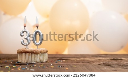 Happy birthday card with candle number 30 in a cupcake against the background of balloons. Copy space happy birthday for thirty years old