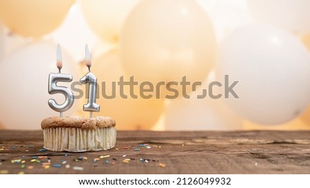Happy birthday card with candle number 51 in a cupcake against the background of balloons. Copy space happy birthday for fifty one years