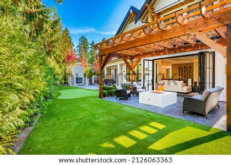 Colorful house with peak roof large windows in autumn fall sunny blue sky and vivid landscaping Royalty-Free Stock Photo #2126063363
