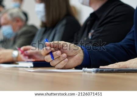 Businessman's hands and pen on the table next to the document. Age official, boss, lawyer or businessman. Retraining. Participation in the meeting and signing of documents. No face. Close-up Royalty-Free Stock Photo #2126071451