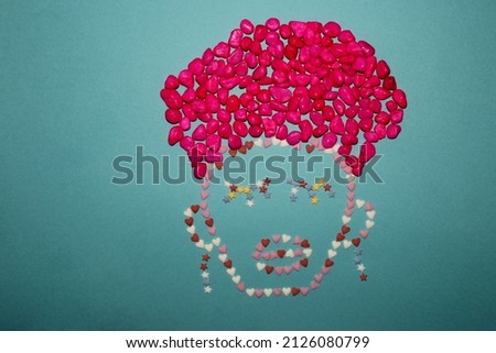 creative concept silhouette of a man with a turban and earrings, a face made of decorative sugar in the shape of a heart and stars and a turban made of pink stones