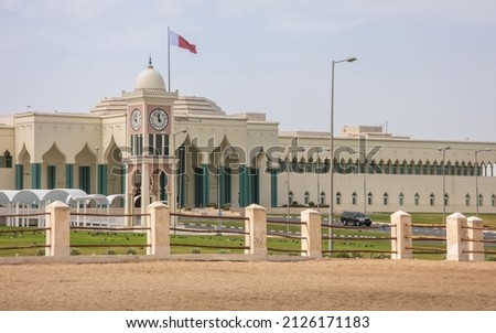 Qatar national flag flying over Amiri Diwan Parliament Building and clock tower, Doha, Qatar Royalty-Free Stock Photo #2126171183