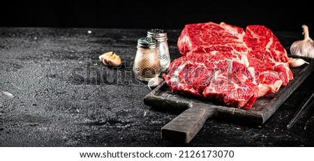 Raw beef on a cutting board. On a black background. High quality photo