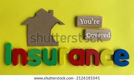 Top view of word Insurance and you are covered with yellow and paper house model background.