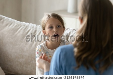 Speech therapist helping kid with pronunciation problems, teaching correct speaking. Teacher training child in sign gestures language, talking nonverbally. Childhood, disability, communication Royalty-Free Stock Photo #2126195894