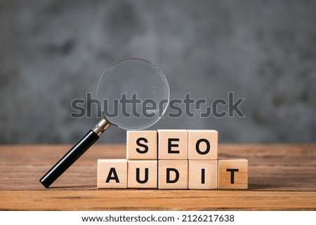 Seo analysis and business concept with wooden blocks with words on it, magnifying glass side view