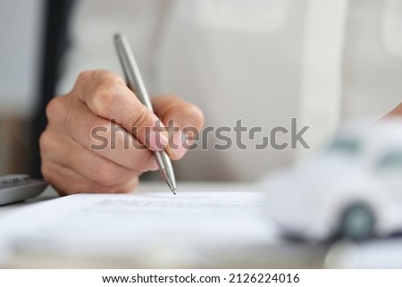 Hands of client signing car rental form. Insurance and car purchase concept