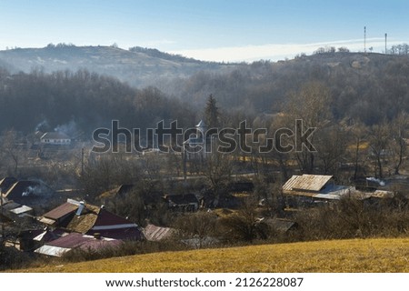 Picturesque traditional village with many houses and church in the center, between the hills, in the valley. Hill valley village country landscape