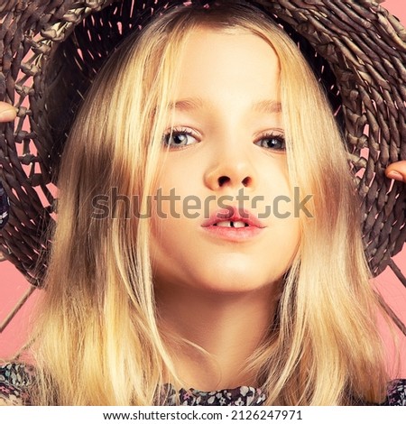 Little girl in hat poses for the camera. Fashion photography
