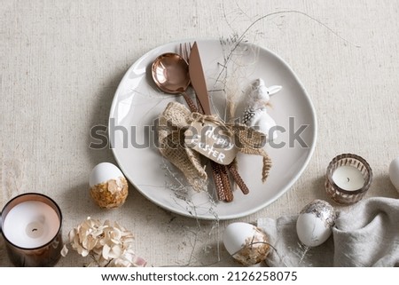 Festive Easter table setting with decor details on white table.