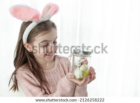 Easter background with a girl in bunny ears and decor, copy space.