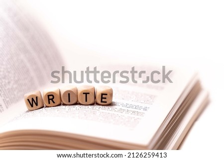 the word WRITE spelled on an open book with wooden letters, concept picture with white background
