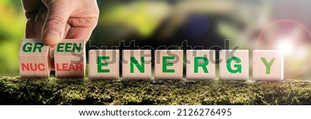 Nuclear or green energy symbol, The businessman turns over the cubes, and the concept of dangerous nuclear energy changes to a safe green one. European green taxonomy, the concept of green energy Royalty-Free Stock Photo #2126276495