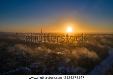 Aerial view of bright yellow sunset over white dense clouds with blue sky overhead. Royalty-Free Stock Photo #2126278547
