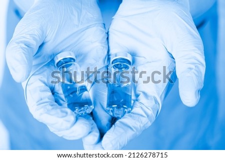 Vaccination, medical vials in the hands of a doctor in medical gloves. Awareness poster. Choice, placebo