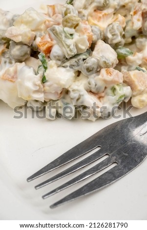 Russian traditional Olivier salad with vegetables and meat. Winter salad for New Year and Christmas. close-up, selective focus